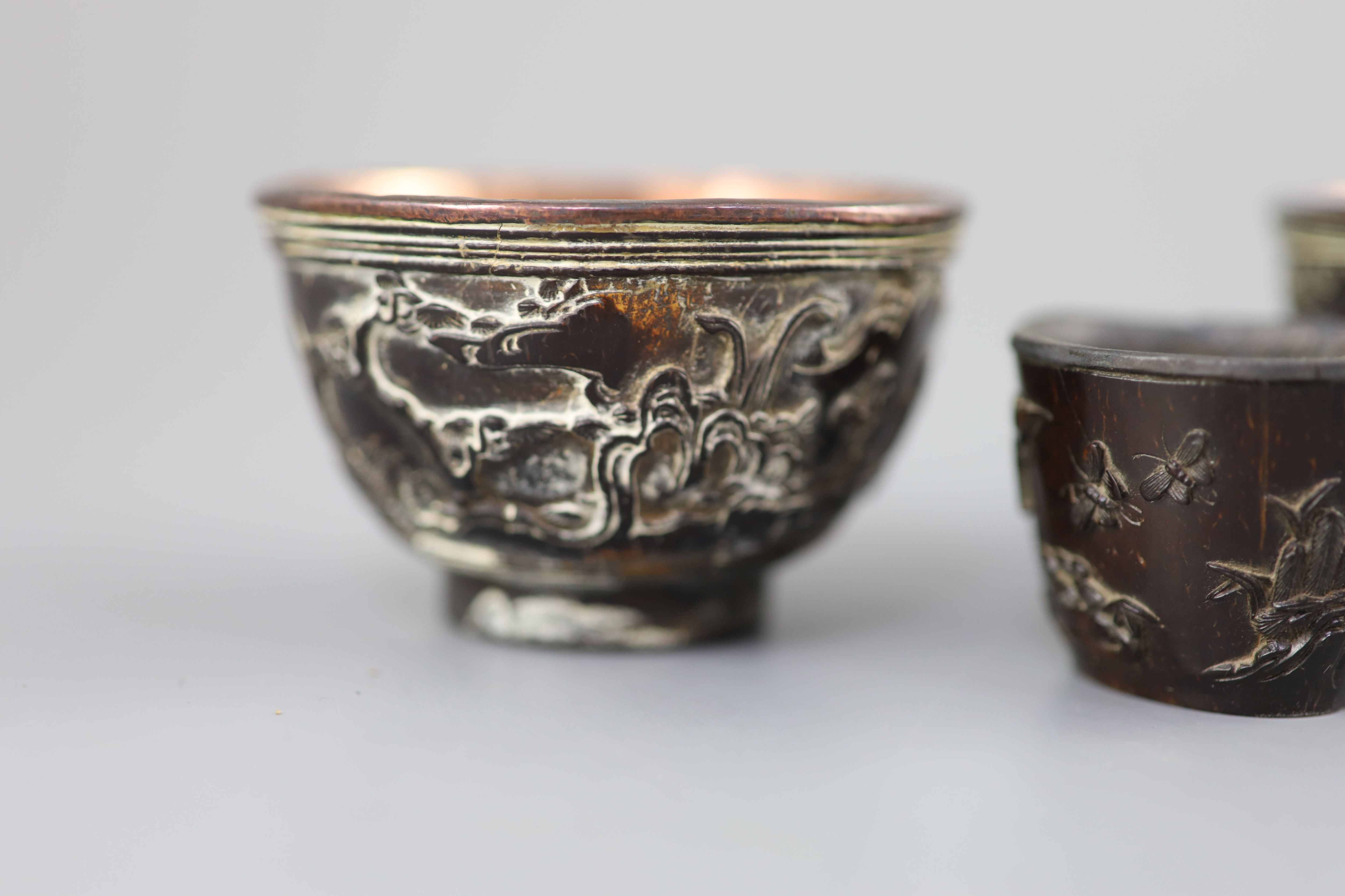 A pair of Chinese coconut landscape cups and a similar peach-shaped cup, 18th/19th century,